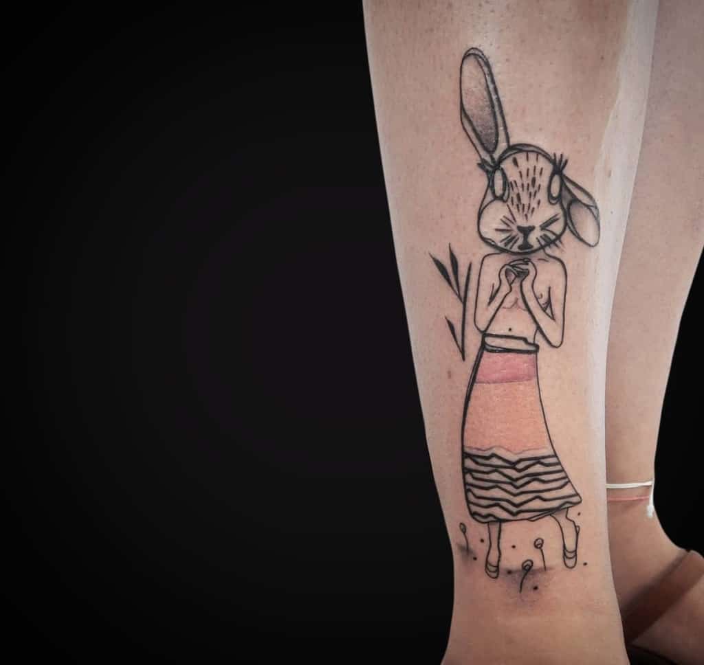 Minimalist tattoo of a humanoid rabbit figure wearing a skirt, blending surreal and abstract elements with fine line and soft shading.