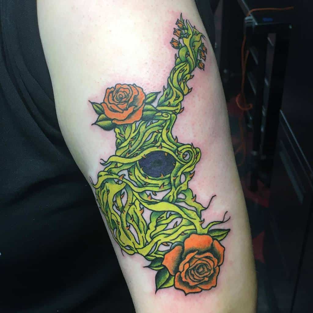 Vibrant tattoo featuring orange roses intertwined with green vines forming a unique abstract design, inked on the arm
