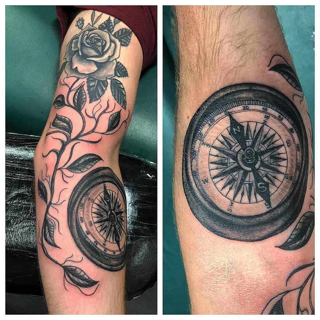 Black and grey tattoo featuring a detailed compass with a blooming rose and flowing vines, elegantly placed on the arm
