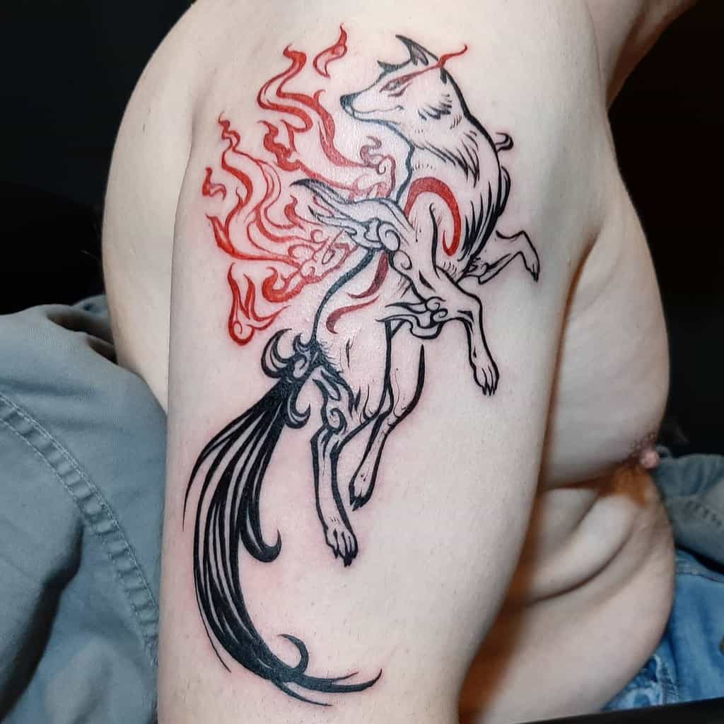 Bold Okami tattoo of Amaterasu in an elegant pose, with flowing black and red ink flames, blending divine energy with a dynamic design