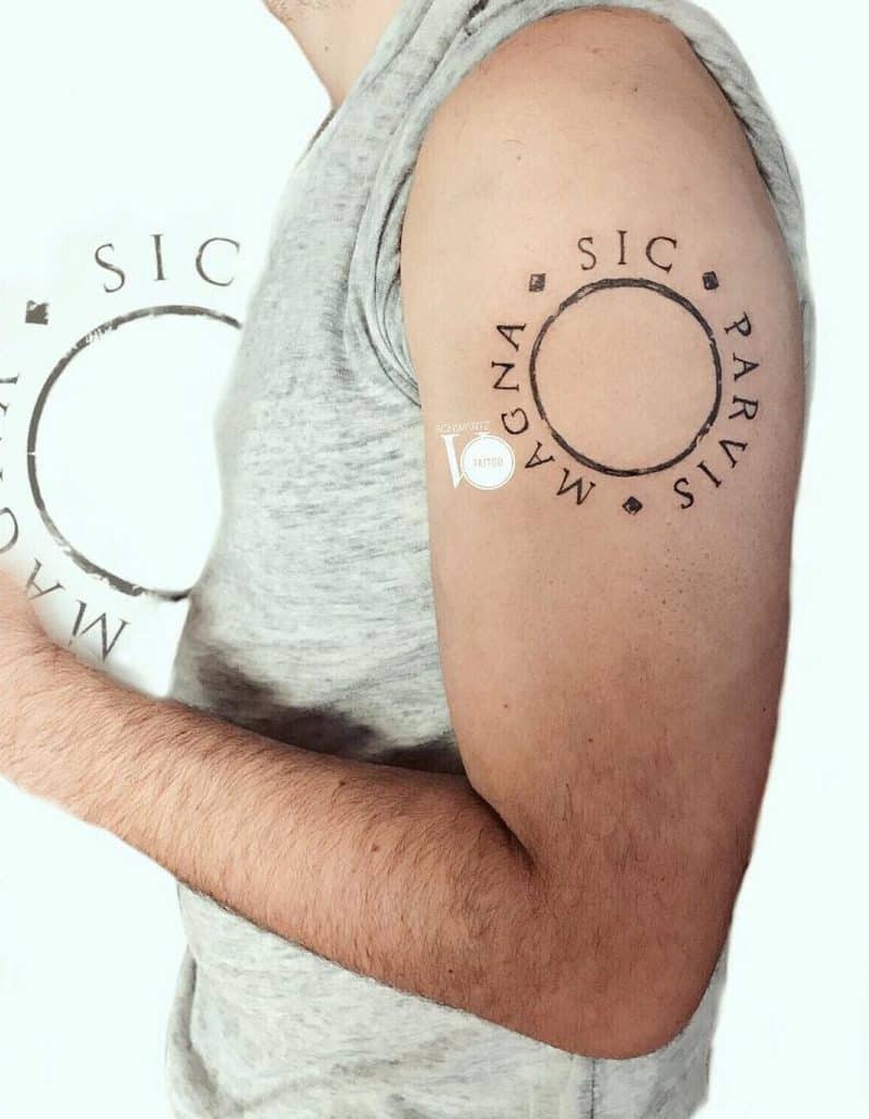 Tattooed arm with Latin phrase "Sic Parvis Magna" around a circle on upper arm