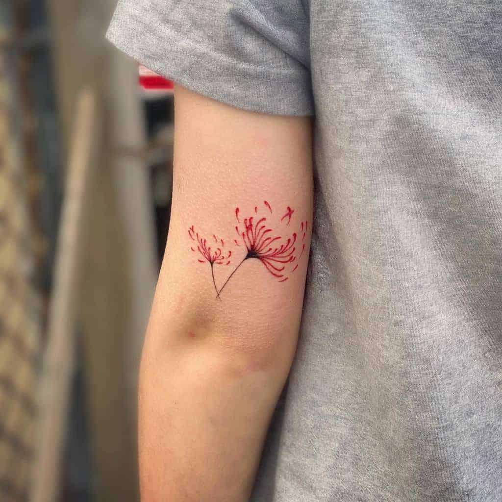 Simple red dandelion tattoo on an arm, with seeds appearing to blow away