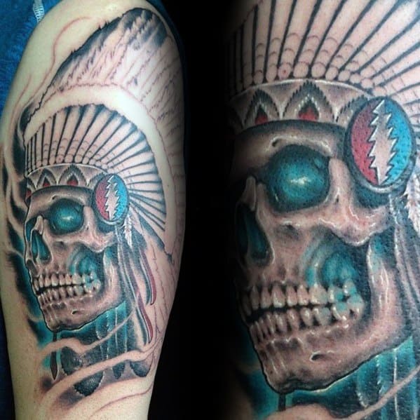Grateful Dead skull tattoo wearing a Native American headdress with the lightning bolt logo on the side, detailed in blue tones.