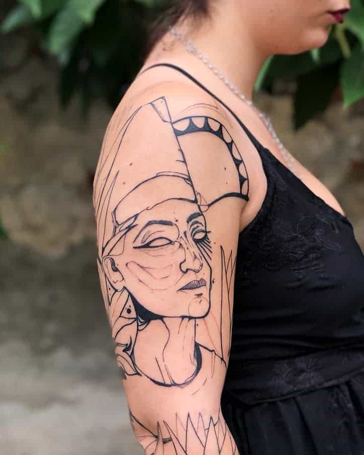 A woman with a Nefertiti line art tattoo on her arm