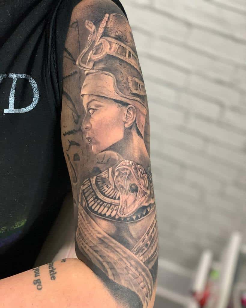Arm tattoo featuring a detailed portrait of Nefertiti with an intricate headdress and jewelry