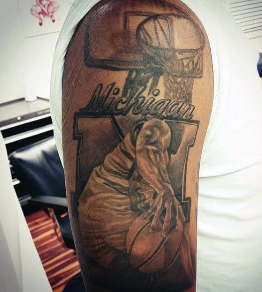 Tattoo of a basketball player dunking, the word "Michigan," and an "M" in the background