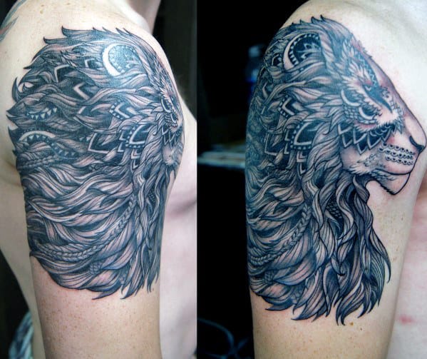 Intricate black and gray tattoo of a lion with mandala patterns on an upper arm
