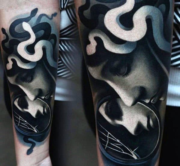 Forearm tattoo of two faces with snake-like patterns in black and white