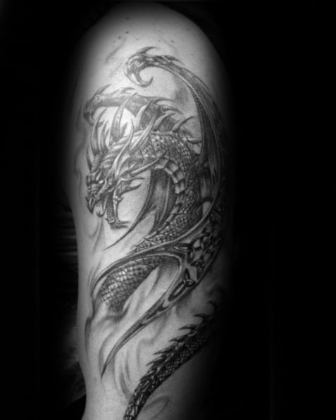 Black and gray tattoo of a dragon wrapping around an arm in a detailed design