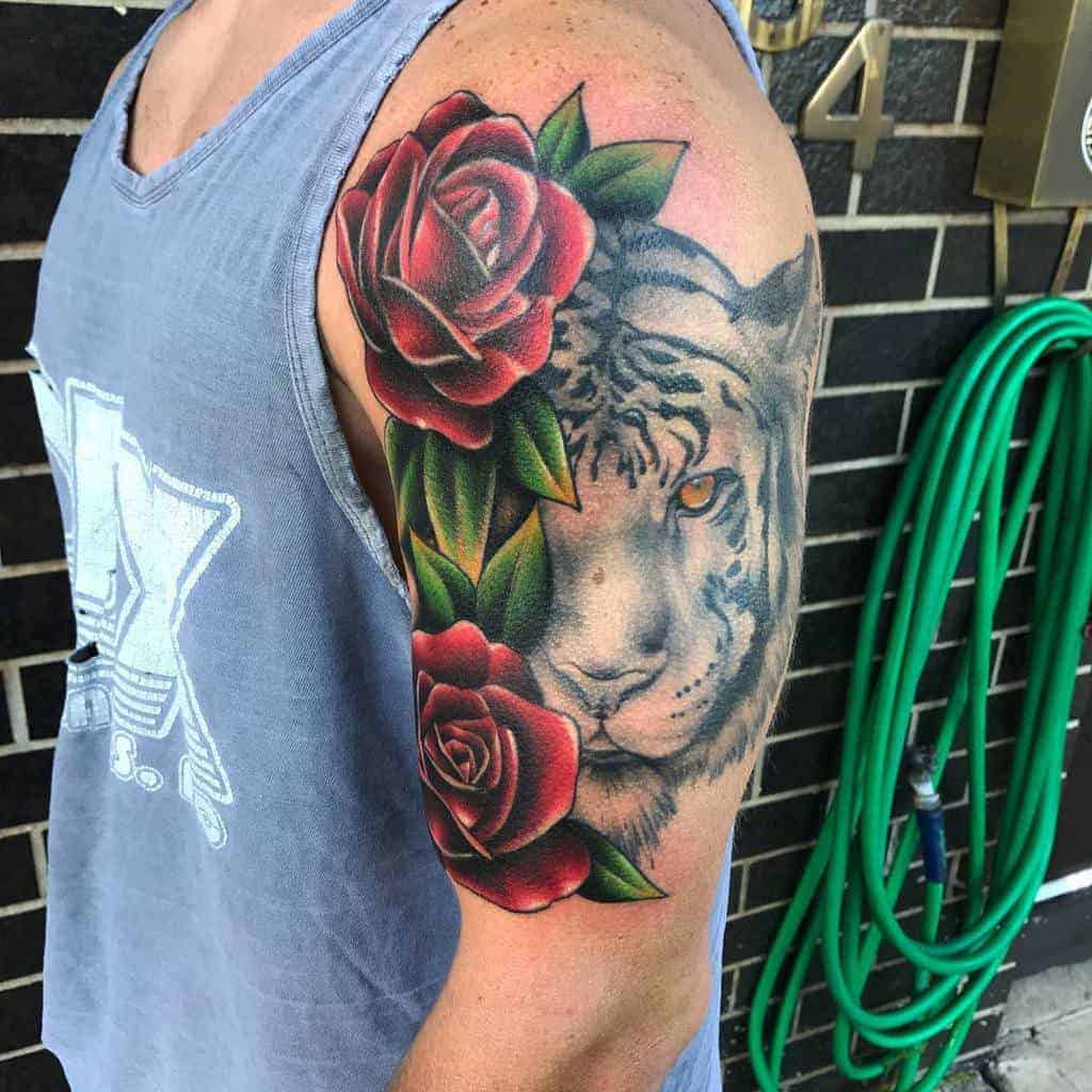 Arm tattoo of a tiger and red roses