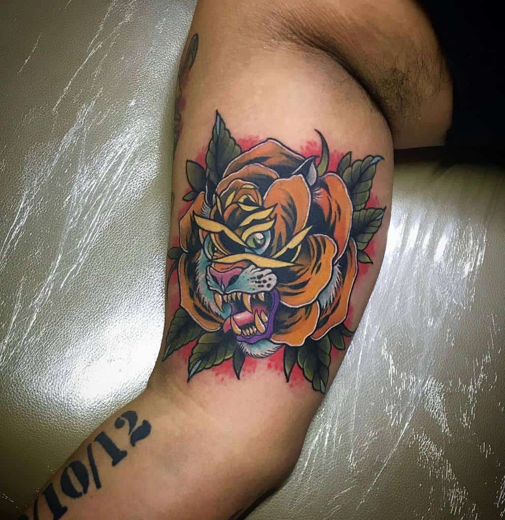 A stunning tattoo graces the person's arm, featuring a tiger entwined with a rose, with vibrant colors and intricate details that bring the majestic creature to life