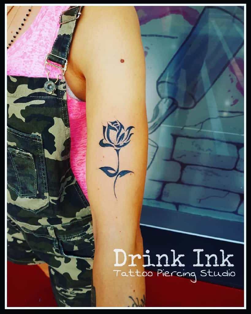 Tribal-infused rose tattoo on an upper arm