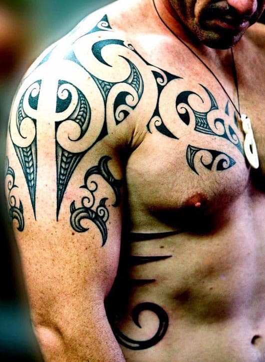 Man with intricate tribal tattoos on shoulder, upper arm, and chest
