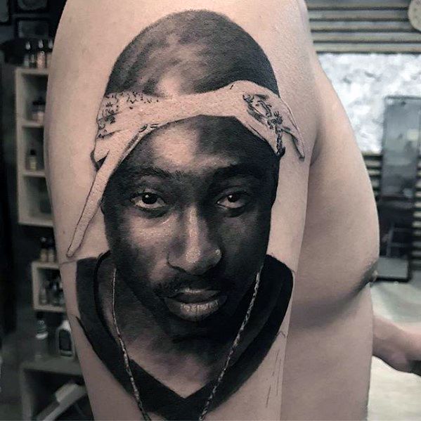 Realistic tattoo of Tupac Shakur, showcasing his iconic bandana and intense gaze