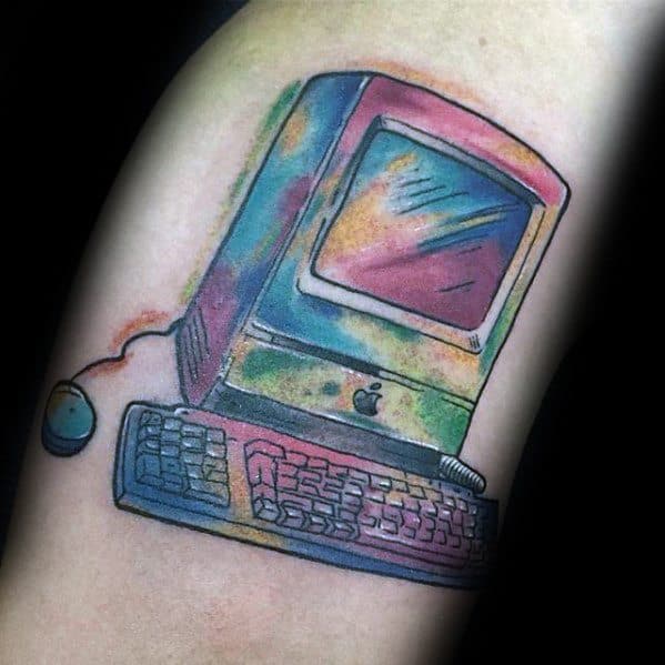 Tattoo of a retro Apple computer in rainbow watercolor style, featuring a classic keyboard and wired mouse.