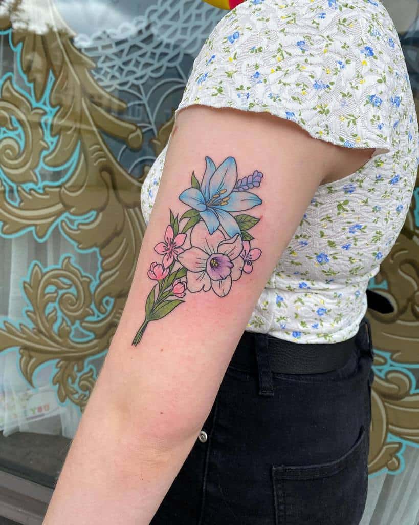 Arm tattoo of various colored flowers, including blue and pink