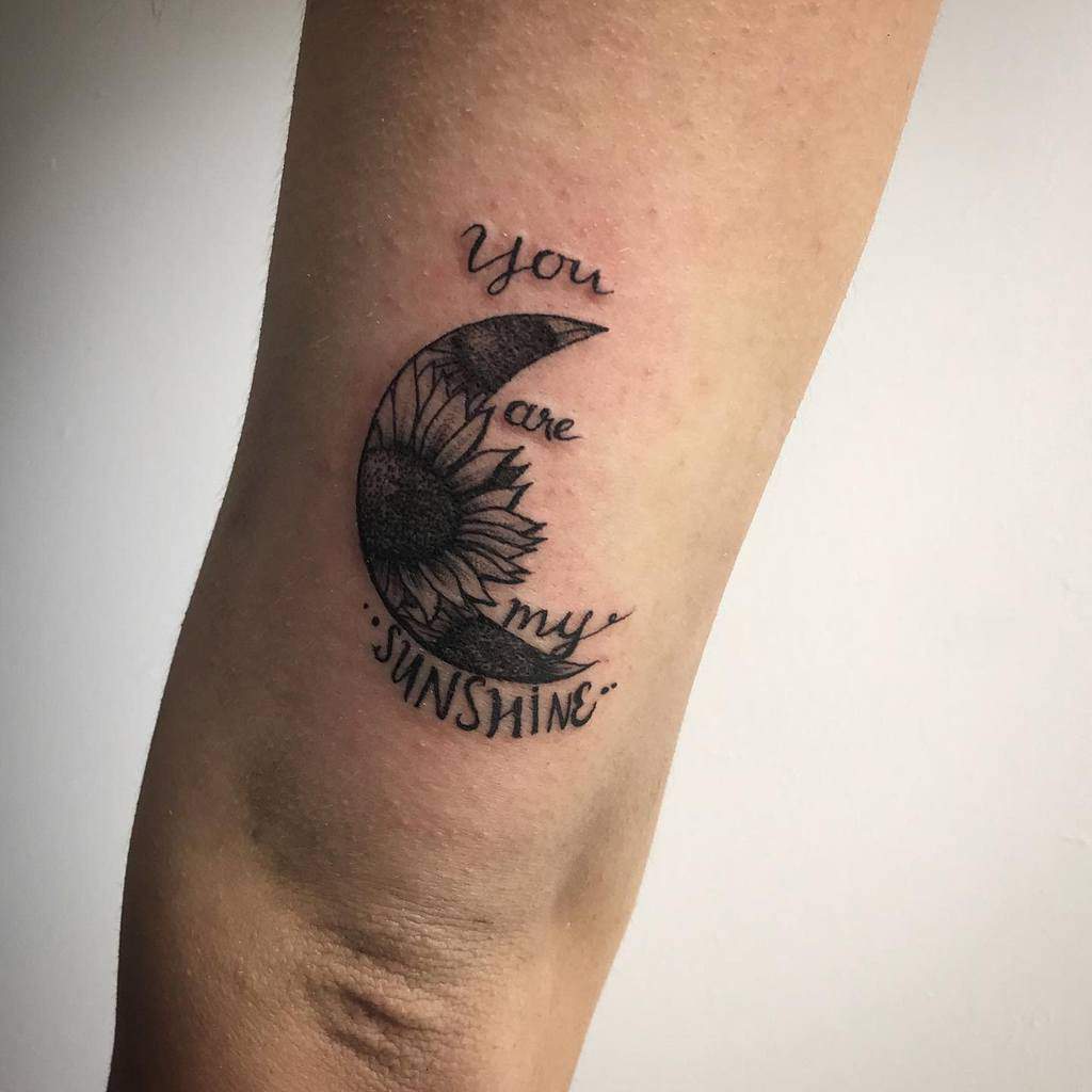 Tattoo of a crescent moon with a sunflower and the words "You are my sunshine"