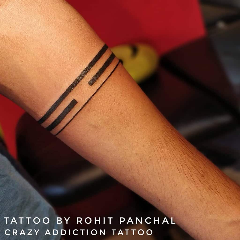 Arm with three parallel black line tattoos above the elbow