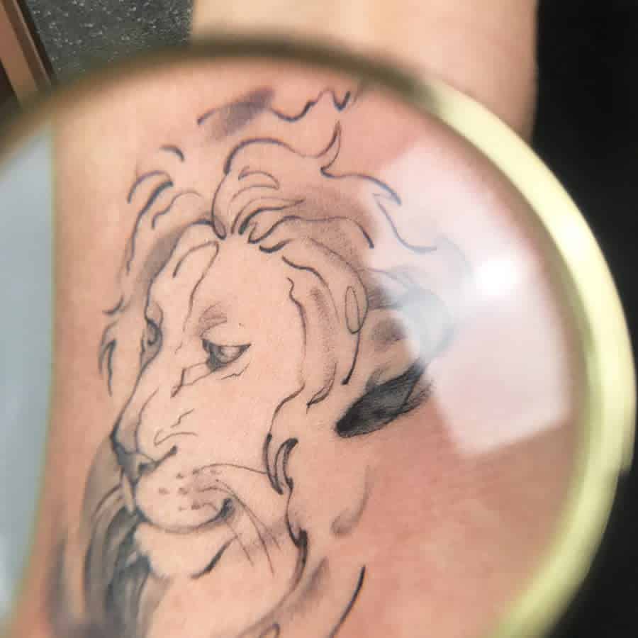 Elegant lion portrait tattoo with flowing mane details, capturing the essence of courage and leadership.