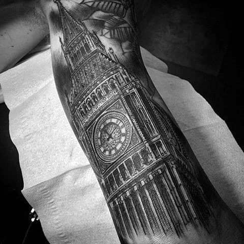 Detailed black and grey tattoo of Big Ben on the forearm, showcasing intricate clockwork design and shading.