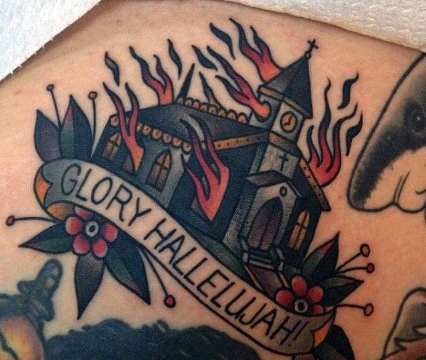 Traditional burning church tattoo with flames and banner reading “Glory Hallelujah!”. Surrounded by flowers and pins.