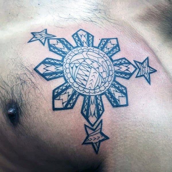 Filipino sun tattoo on the chest featuring detailed tribal patterns with three stars and bold geometric rays.