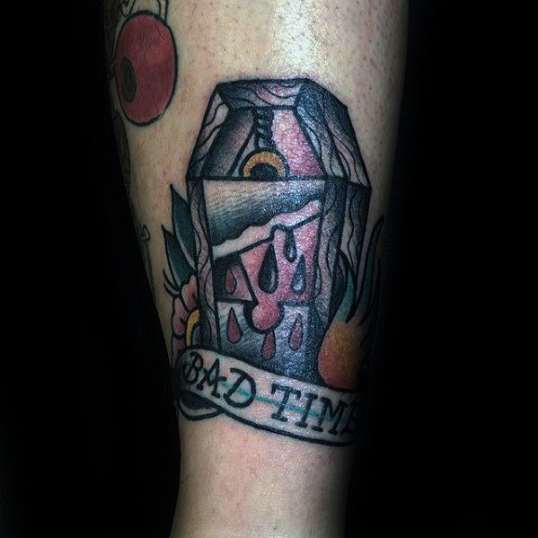 Colorful guillotine tattoo with dripping blood, flowers, and a banner that reads "BAD TIMES" at the bottom.