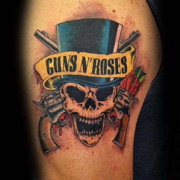 Colorful tattoo of a skull in a top hat with "Guns N' Roses" banner, crossed pistols, dripping blood, and a red rose in the background.