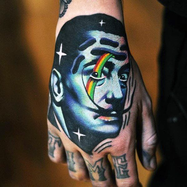 Bold Salvador Dali hand tattoo with neon blue tones, rainbow eye detail, and surreal star accents for a cosmic, dreamlike look.