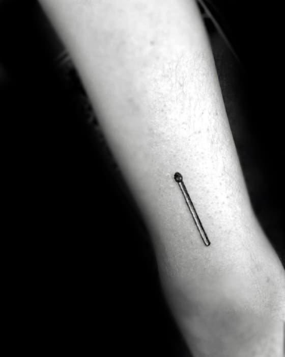 Minimalist matchstick tattoo on forearm symbolizing potential, spark, or ignition in a clean black ink design.