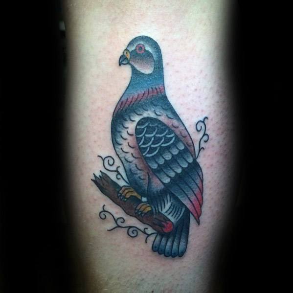 Traditional-style pigeon tattoo with red and grey tones, perched on a branch with decorative swirls for a bold and classic look.