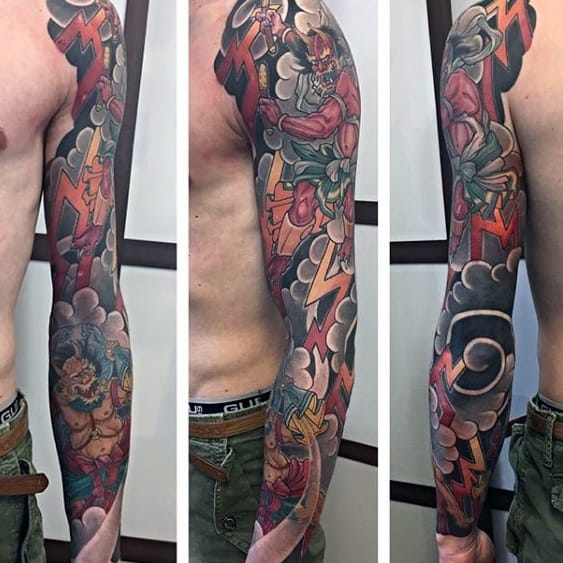 Raijin full sleeve tattoo with lightning bolts, storm clouds, and fierce deity imagery in bold red, orange, and black tones.