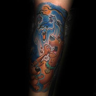 Tattoo of Scooby-Doo and Shaggy looking scared as a ghost rises behind them, with vibrant blue and orange background tones.