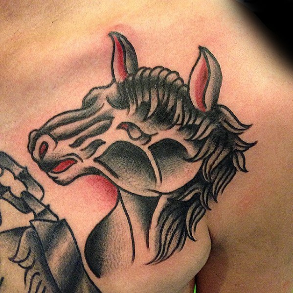 Traditional horse tattoo on the chest showing a stylized black and grey horse head with bold shading and red accents in the ears.