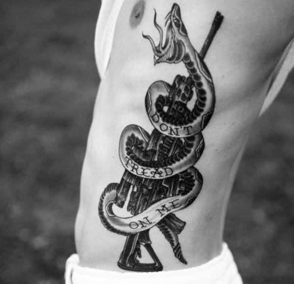 Assault Rifle And Angry Snake Black Ink Tattoo With Dont Tread On Me Text On Guys Side