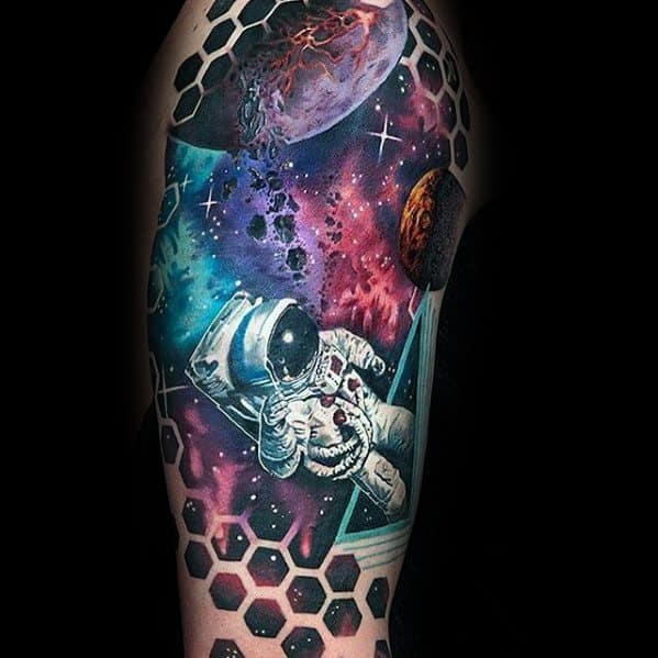 Tattoo of an astronaut floating in a nebula, surrounded by planets and a hexagonal pattern