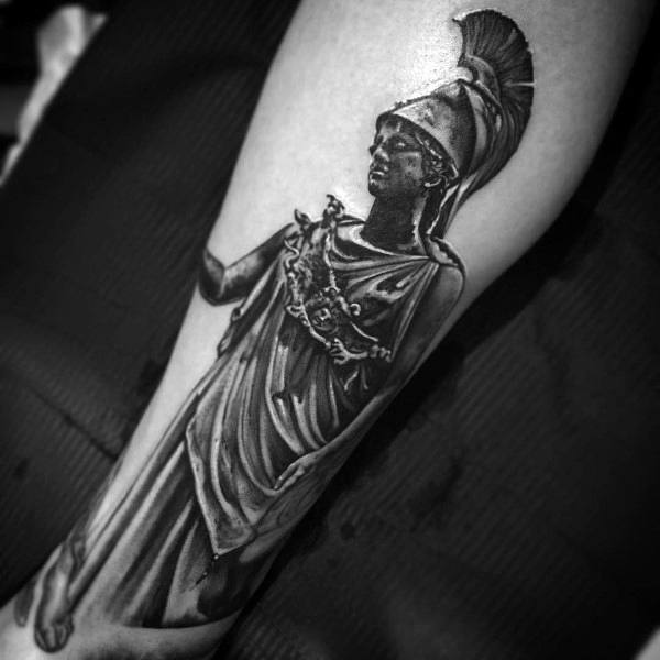 Athena tattoo on forearm featuring detailed armor, flowing robes, and helmet in realistic black and grey shading