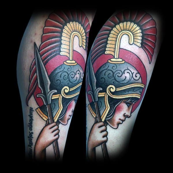 Athena tattoo in neo-traditional style with bold lines, red and gold helmet, spear, and shaded profile on forearm
