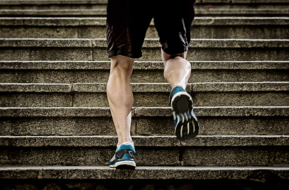 athletic legs of young sport man running on staircase steps