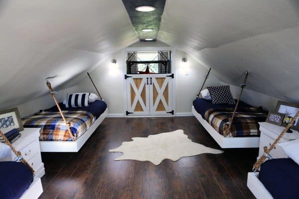 Cozy attic bedroom with twin hanging beds, plaid bedding, and barn-style doors for a rustic look.
