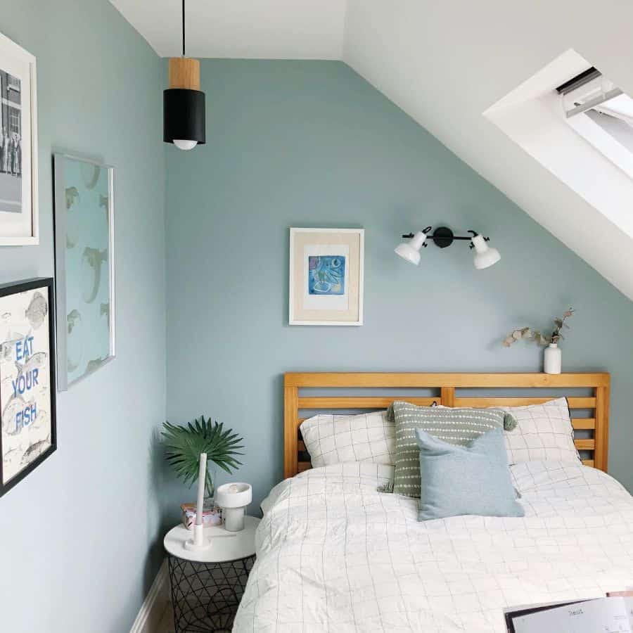 attic bedroom blue walls skylight wood bed frame