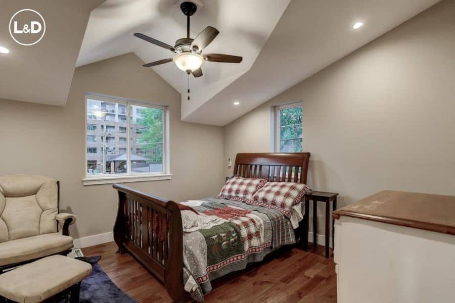 traditional loft bedroom wood bed gray lounge chair ceiling fan with light