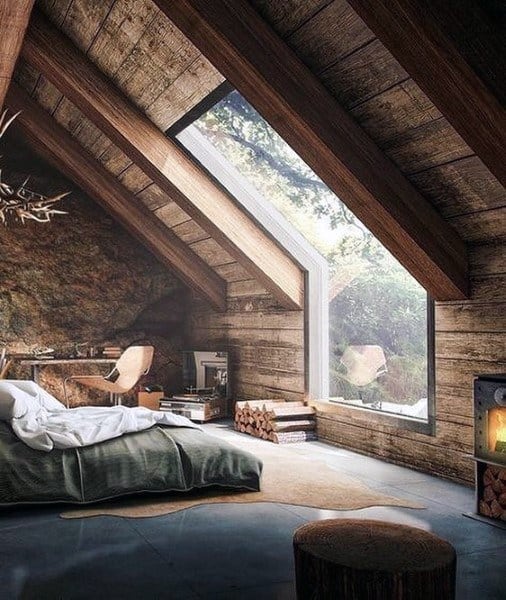Cozy wood cabin attic bedroom with platform bed, wood stove, and scenic window.