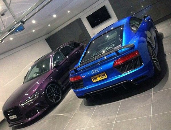 A sleek home garage featuring two luxury Audi cars, highlighted by modern lighting and a tiled floor.