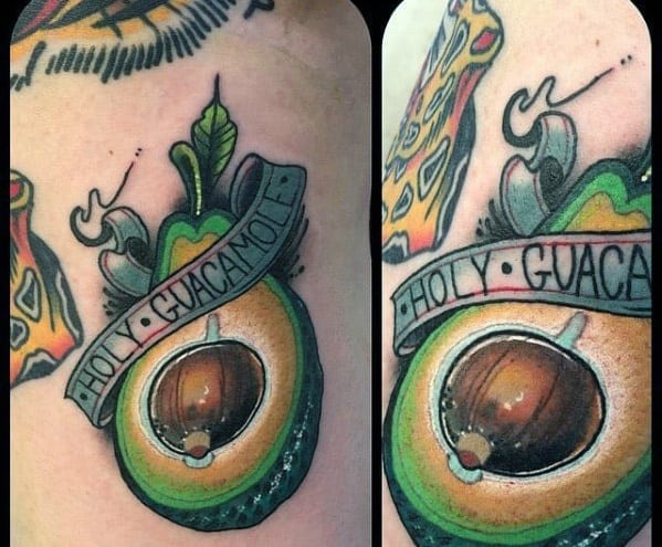 Glossy avocado tattoo with a banner reading “Holy Guacamole,” surrounded by vibrant details and traditional-style embellishments.