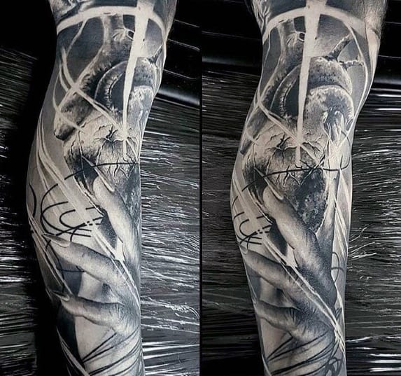 Black and gray tattoo of a realistic heart and hands with abstract streaks and lines covering a forearm