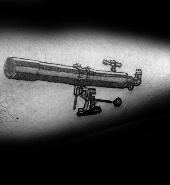 Telescope tattoo with intricate black ink details on an arm