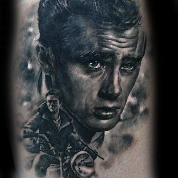 Black and grey tattoo of James Dean’s intense gaze above a scene of him riding a vintage motorcycle.