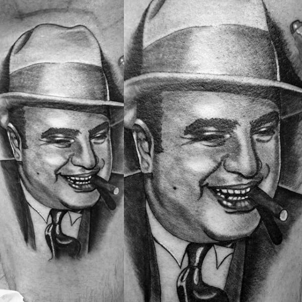 Al Capone tattoo featuring a close-up, black-and-white portrait of the gangster smiling with a cigar, wearing his iconic fedora.