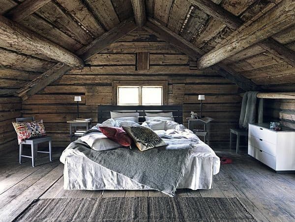 Cozy rustic attic bedroom with a wooden ceiling, large bed, and soft lighting